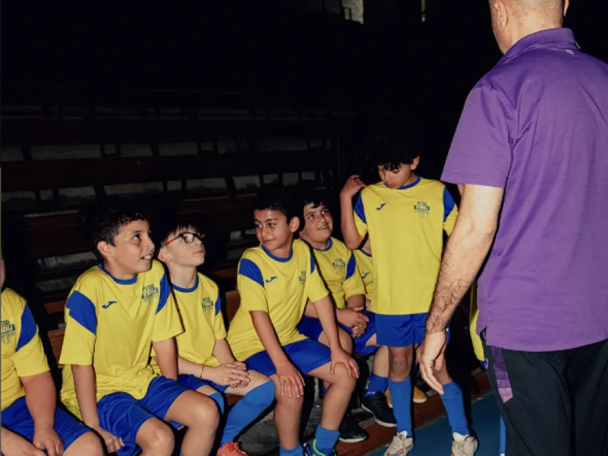 kinderen in voetbaltruitjes met trainer
